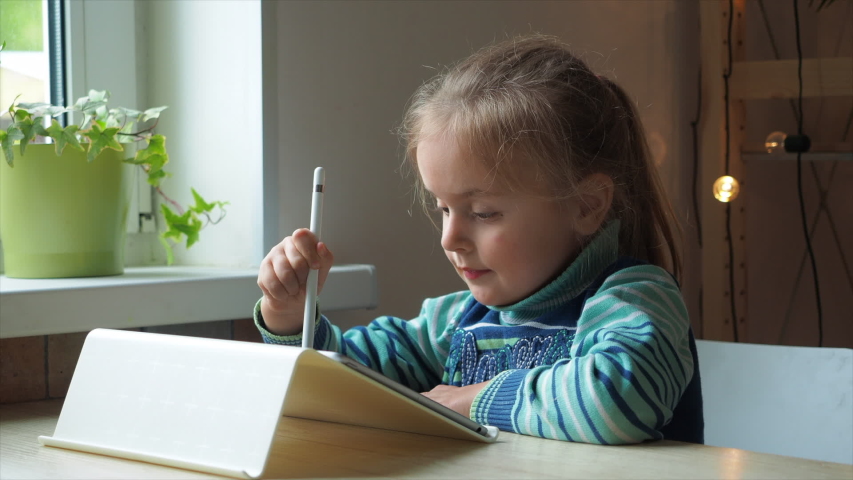 Little girl with tablet and stylus learning drawing online. Remote education concept