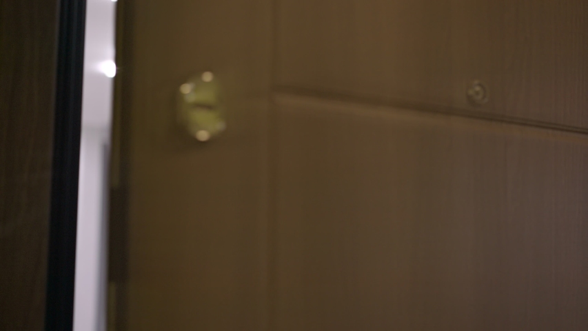 beautiful woman opens door and gets amazing bunch of flowers from deliverer signing delivery receipt closeup