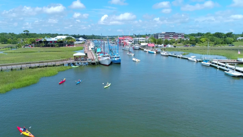 Shrimp Boats in creek during the daytime. Filmed at Shem Creek in Mount Pleasant, SC. Just outside of Charleston, South Carolina. Royalty-Free Stock Footage #1053262412