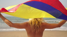 Young beautiful woman is sitting on the beach with the flag of Colombia - Powered by Shutterstock - Get 15% off with code: PIKWIZARD15