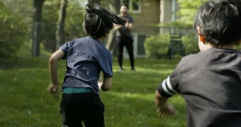 Brothers excitedly run into their father's arms. Loving family fathers day.  Shot in slow-motion on RED camera in 4k. 
 Arkivvideo