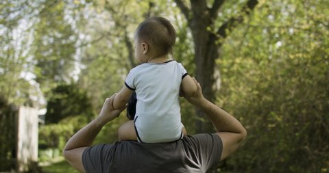 Son on father's shoulders. Loving father's day. Slow-motion captured in 4k.  - Βίντεο στοκ