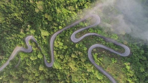 aerial footage of the twisted road through beautiful Perlis Jungle named Wang Kelian in Malaysia during sunrise.  Footage in 4K Quality.