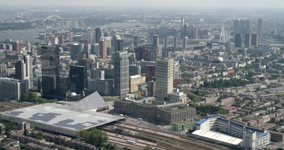Aerial of city centre of Rotterdam with the urban skyline of one of europe's biggest harbors in Rotterdam, the Netherlands. Central station with trains. Shot on RED.  Royalty-Free Stock Footage #1053281045