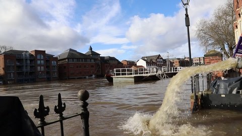 Flood water being pumped out of a flooded road into the River Ouse in the centre of York