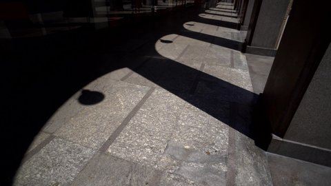 Empty city streets and galleries on Corso Vittorio Emanuele II. Shadow and light. The shadow of the pillars. Movement of the camera forward. The columns. Arches. Marble flooring