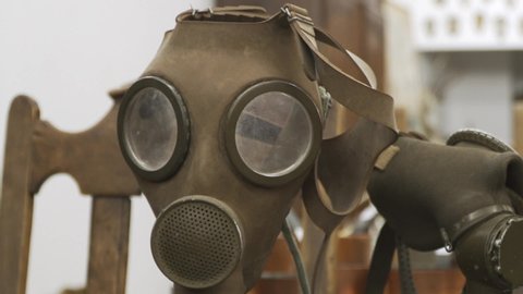 Tilting shot of old military gas mask to rusty tool. Gasmask tilt-down