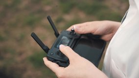 Female hands holding a controller from a drone