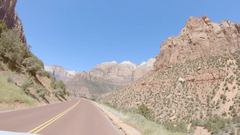 Car mounted camera, driving trough stunning mountain landscape in Wester USA. Point of view vehicle driving in Zion National Park. Road trip freedom concept 