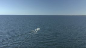 Aerial view of motor boat traveling in the middle of the ocean