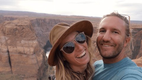Young couple taking selfies in wester USA. People travel concept. Couple takes selfies at horseshoe bend in Arizona. Spectacular canyon formation, selfie time 