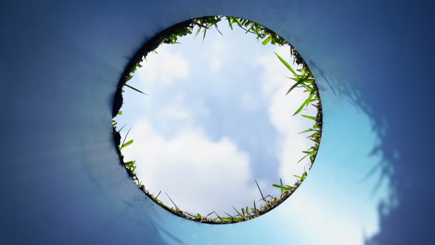 Hole in one successful putt. Golf ball going down hole with blue sky. 