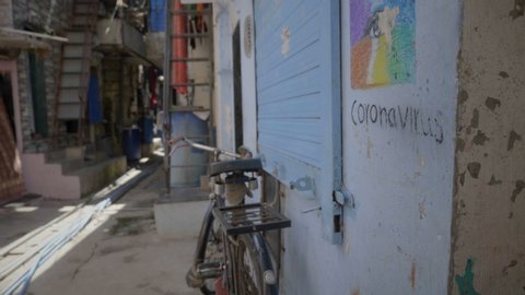 A movement shot of empty lane closed shops and art work graffiti about coronavirus awareness is drawn on the wall in slums during lockdown amid coronavirus COVID19 epidemic pandemic in India
