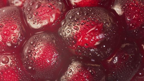 Close up footage of bright fresh red Pomegranate fruit seeds on white background with water mist. Health, vibrant organic and antioxidant fruit concepts. Slow Motion, RED Camera.