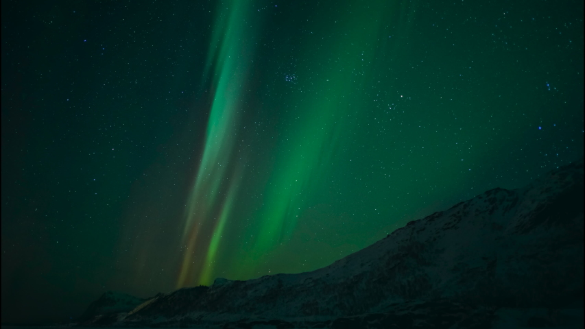 Northern Lights, polar light or Aurora Borealis in the night sky over the arctic landscape of the Lofoten islands in northern Norway. Time lapse video.