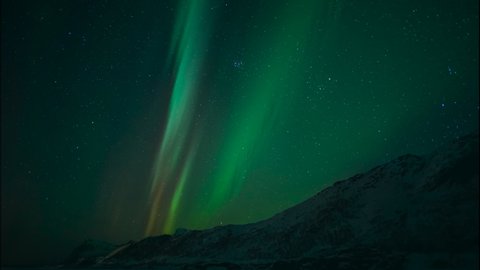 Northern Lights, polar light or Aurora Borealis in the night sky over the arctic landscape of the Lofoten islands in northern Norway. Time lapse video.