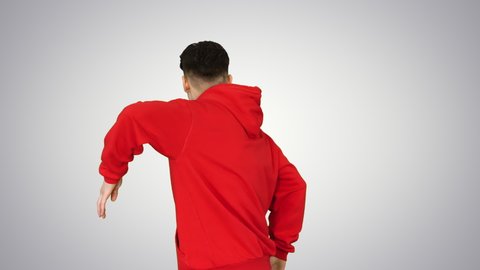 Young man dancing hip-hop doing waves on gradient background.