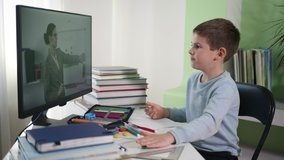 male child learns lessons online with his teacher using modern technology, distance education