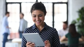 Head shot friendly young indian female manager using digital computer tablet in office. Smart biracial businesswoman working on electronic device, communicating with clients online at workplace. - Powered by Shutterstock - Get 15% off with code: PIKWIZARD15