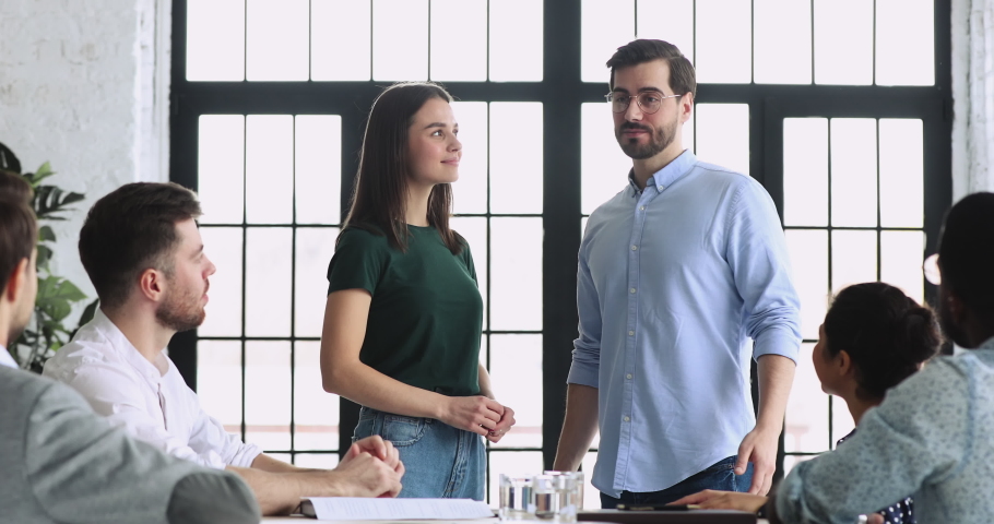 Smiling young male team leader boss introducing new project manager to multiracial colleagues in office. Pleasant female newcomer having first working day, getting acquainted with diverse coworkers. Royalty-Free Stock Footage #1053336149