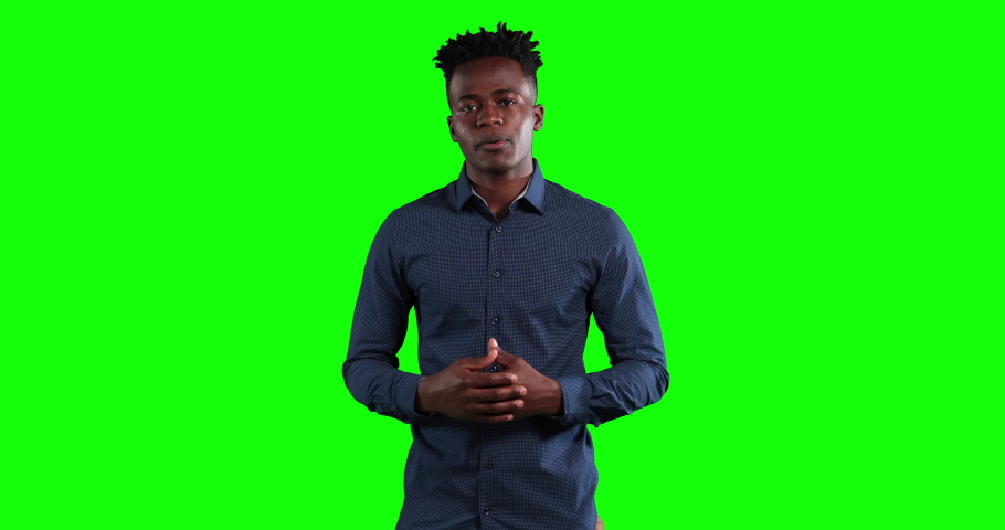 Attractive African American businessman with short dark hair, wearing a dark shirt, talking and gesturing, looking at camera on green screen background Royalty-Free Stock Footage #1053345434