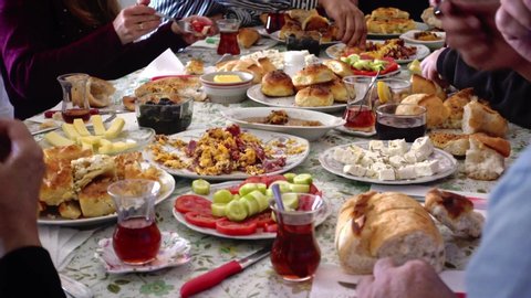 Crowded and hungry Turkish Muslim family having delicious breakfast together (traditional serpme kahvalti) to celebrate Eid-ul-fitr, Feast of Sugar, after the holy month Ramadan