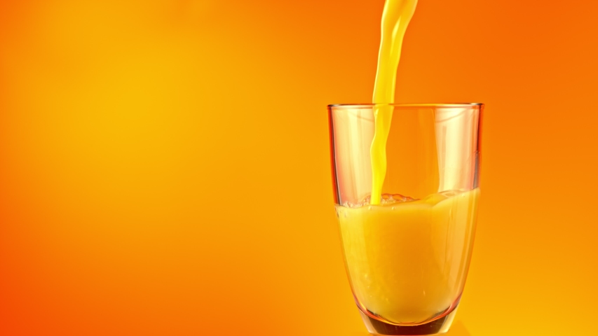 Super Slow Motion Shot of Pouring Fresh Orange Juice into Glass at 1000 fps. Royalty-Free Stock Footage #1053362003