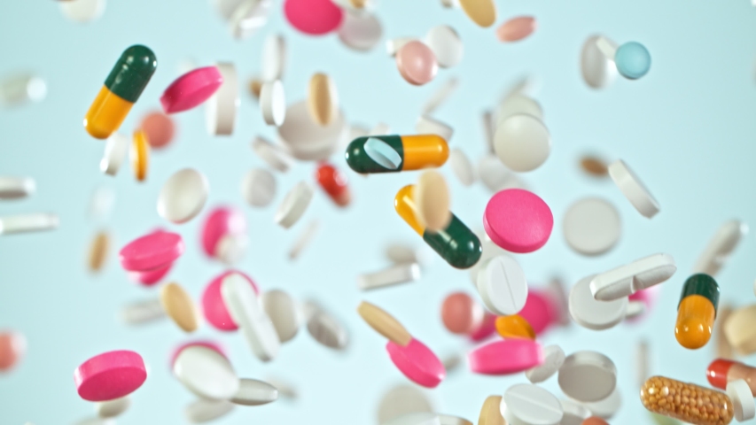 Super Slow Motion Shot of Flying Colorful Pills on Gradient Background at 1000fps. | Shutterstock HD Video #1053362018