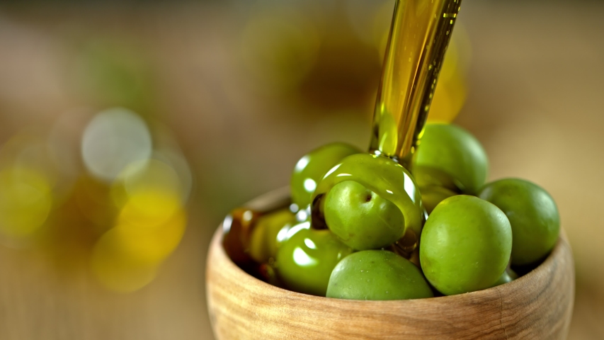 Super Slow Motion Shot of Pouring Fresh Olive Oil on Olives at 1000 fps. Royalty-Free Stock Footage #1053362024