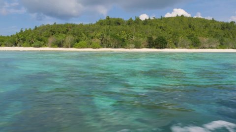 Sitting on a fast-moving boat, the clear blue water passed by quickly, and an island covered with green trees swept quickly.