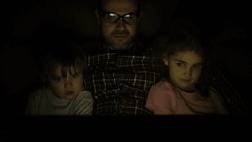 Happy Family While Watching TV on Laptop. Father with Son and Daughter Together Watch Cartoon on Laptop on Living Room. Concept Video Game, Entertainment, Emotions, Family. Children Watching TV.