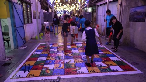 Bukit Mertajam, Penang / Malaysia - Jan 20 2020: Children exiting play large ladder board game at street.