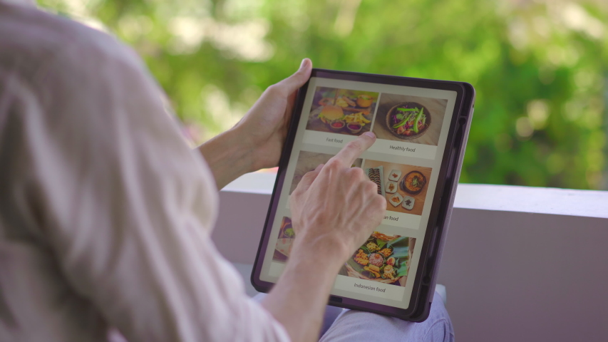 A man orders food for lunch online using tablet. Online shoping concept