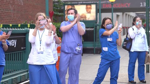 New York City, New York / USA - May 29 2020: New York hospital healthcare workers and nurses clapping expressing gratitude for saving lives during pandemic coronavirus outbreak in New York City.