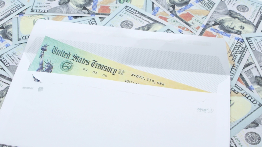 Man opening envelope with coronavirus american stimulus check over a big pile of hundred dollar bills. Concept IRS tax refund or coronavirus stimulus payments. Global pandemic. Covid 19 lock down Royalty-Free Stock Footage #1053379997