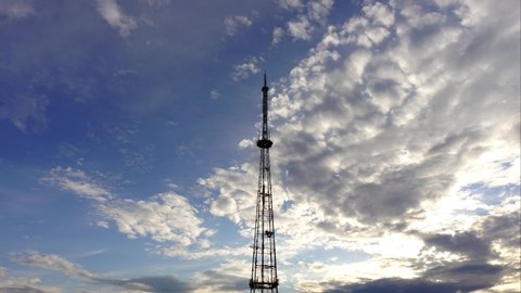 A TV tower amid the clouds. Time lapse.