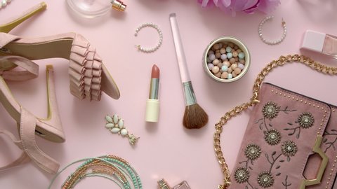Beauty and fashion accessories and gadgets. Femine concept. Flat lay on pink theme background. With shoes, purse, cosmetics, flower.