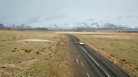 Beautiful road on a volcanic landscape in Iceland. Drone flying behind the car. Iceland 4K drone video.