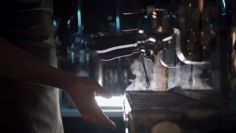barista make hot black espresso in coffee machine