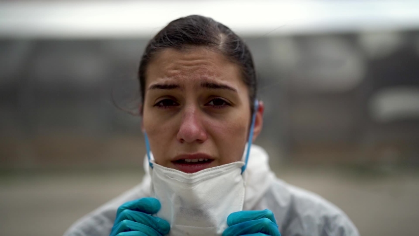 Exhausted doctor / nurse taking of coronavirus protective gear N95 mask uniform.Coronavirus Covid-19 outbrek.Mental state of medical professional.Face scars.Mask shortage.Overworked health workers	 | Shutterstock HD Video #1053409055
