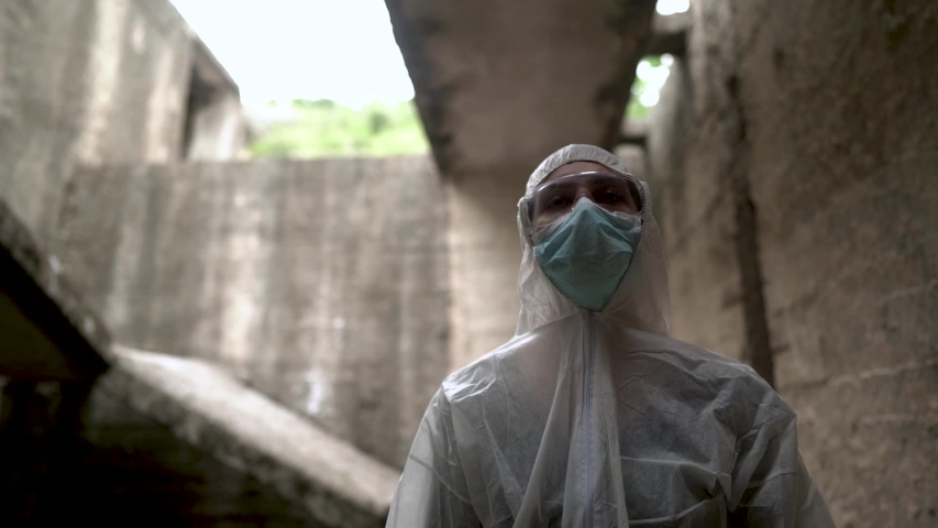 Coronavirus doctor standing in front of ruined clinic building isolation ward.Medical professional in protective equipment in fight against COVID-19.Triage performing medical worker.	 | Shutterstock HD Video #1053409064