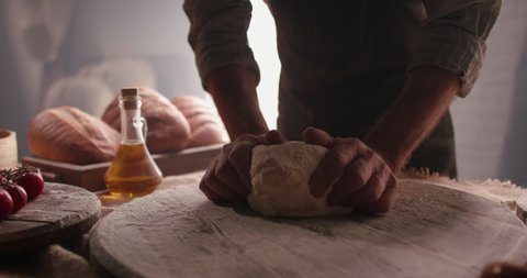 Hands of senior professional chef kneading floured dough for bread in bakery shop in the morning. Retiree enjoying new hobby making homemade bread close up 4k footage