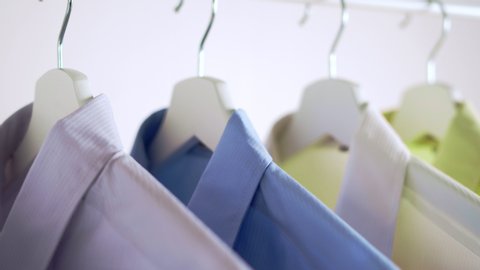 Close up of Colorful Shirts on hangers, apparel background, Slider shot