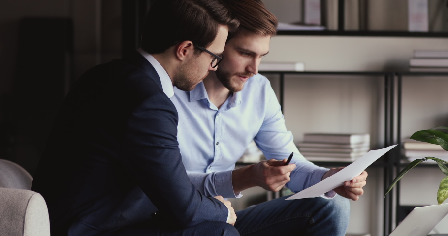 Two businessmen working on financial statistics analyzing charts project data in report doing paperwork. Executive analysts discussing business diagrams, corporate graphs consulting at office meeting. | Shutterstock HD Video #1053421106