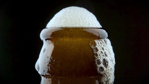 Men's hands open bottle of beer. Beer foam escapes from under the lid.