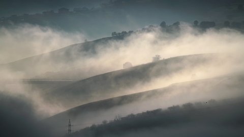 Cinematic 8K 7680x4320.Mist lying in the folds of hills.Condensation and evaporation in nature.Misty fog foggy cloud cloudy clouds fogs hill air damp vapor weather land surface moisture cold winter 8K