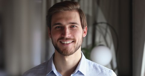 Smiling bearded millennial professional businessman looking at camera. Happy confident handsome smart young adult entrepreneur, leader, manager posing in office. Close up face view business portrait