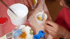 Young girl mixing paint with a paint brush, DIY concept