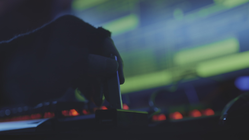 Close up of unrecognizable person hand connecting USB flash drive to the computer in dark computer club