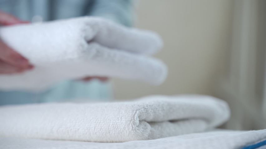 A woman touches a fresh white towel | Shutterstock HD Video #1053442364